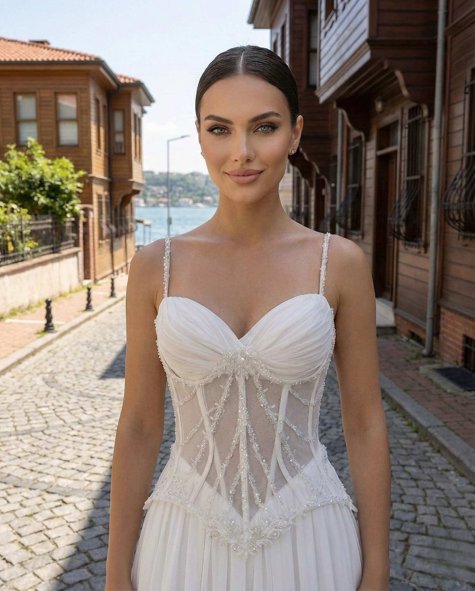 Atelier Mila Kadıköy özel tasarım, el işçiliği kristal taş işlemeli, göğüs drapeli, ince askılı ve transparan korseli gelinlik detayı.