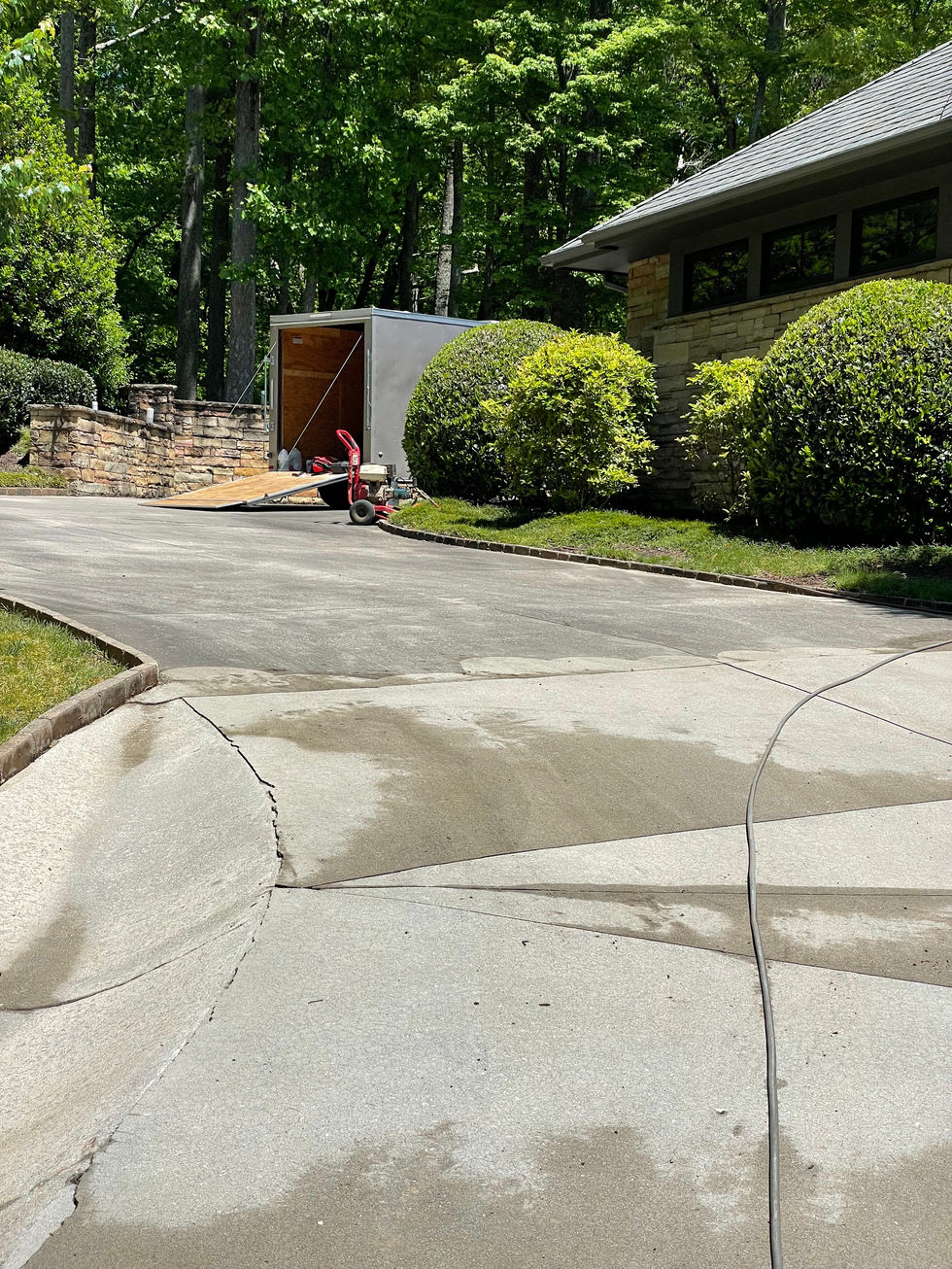 Pressure washing a dirty concrete driveway