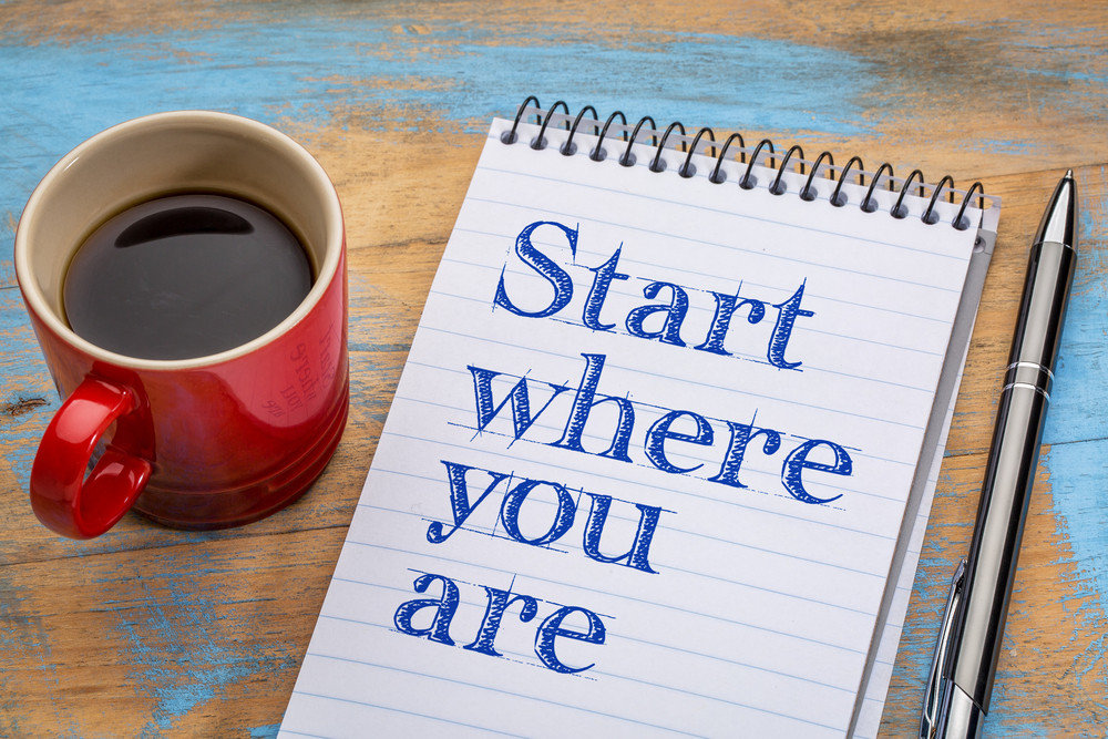Notepad reading Start wher you are and coffee mug