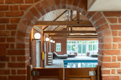 View through brick archway to indoor swimming pool