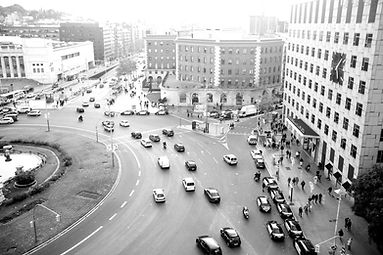 Calle concurrida de ciudad con coches y edificios.