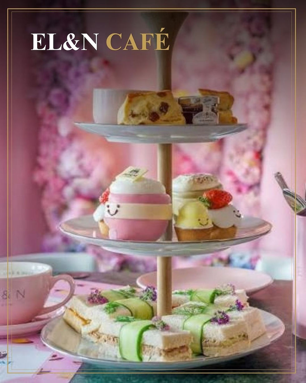 EL&N CAFÉ: pastel etagère met gebak, sandwiches en kopjes op een roze bloemenachtergrond in een gezellige theesetting