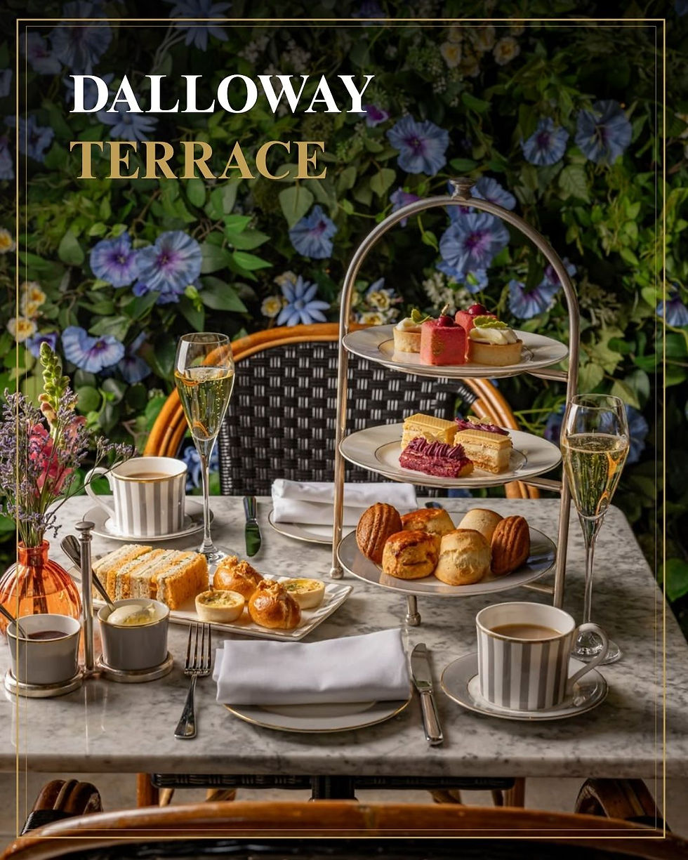 High tea op marmeren tafel met taartjes, scones en champagne; bloemenwand op achtergrond met tekst DALLOWAY TERRACE