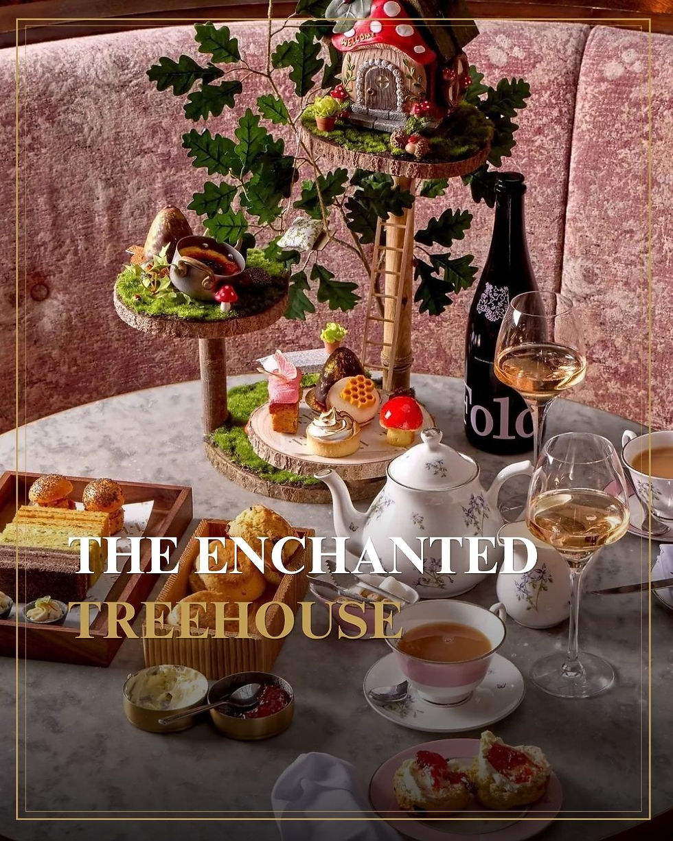 Feestelijk theetafel met taartjes, thee en wijn naast mini-boomhuis; tekst: THE ENCHANTED TREEHOUSE.