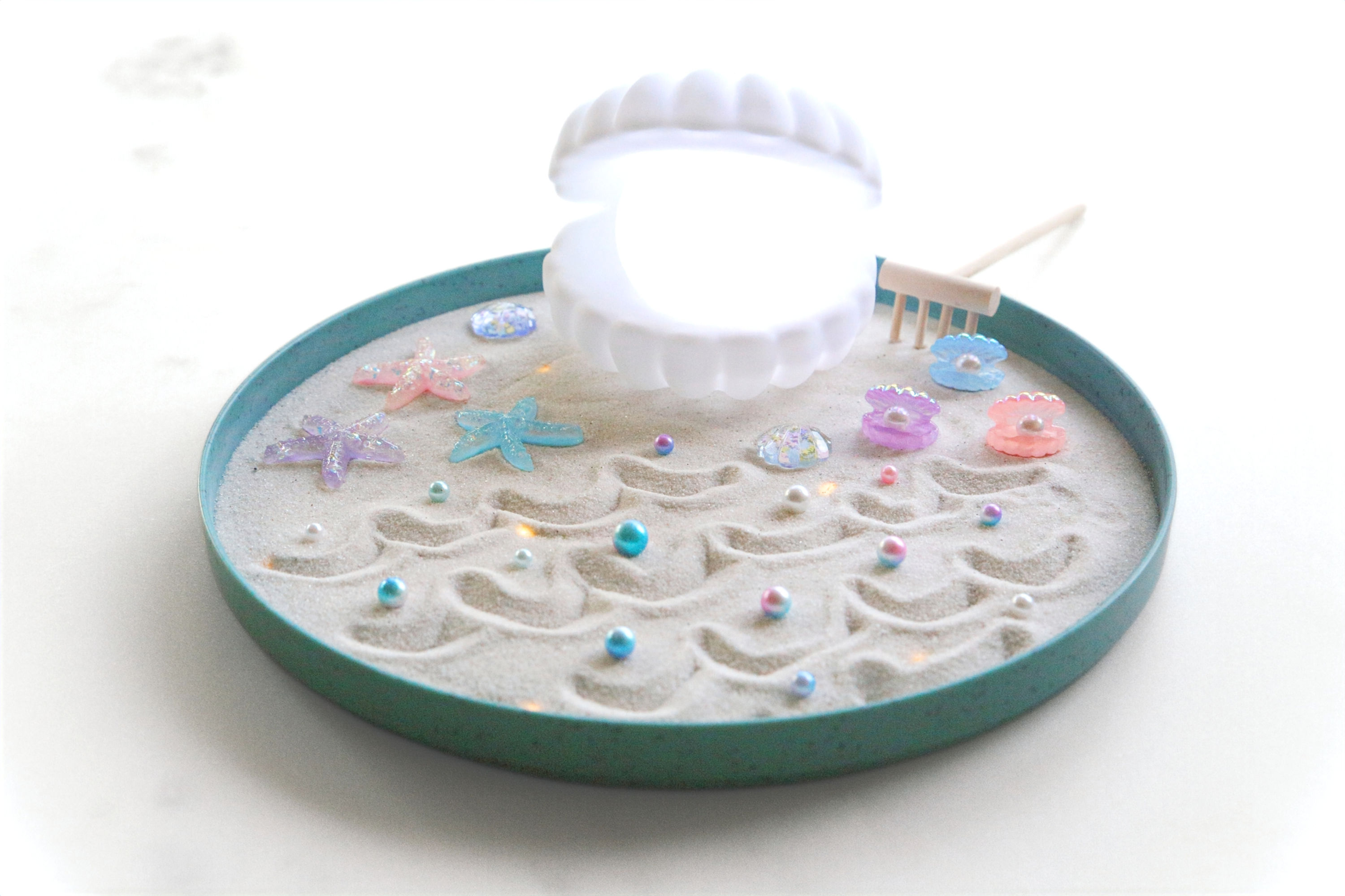 Miniature zen garden with seashells and starfish