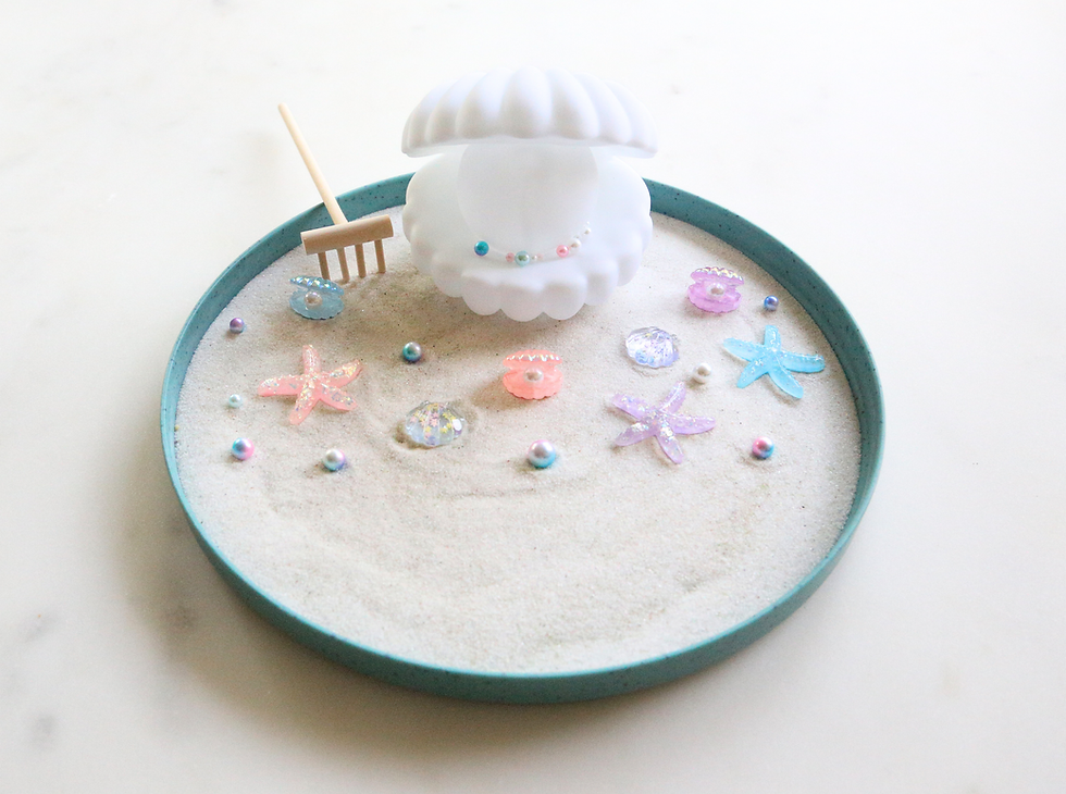 Thumbnail: Miniature Zen garden with seashells, starfish, and pearls