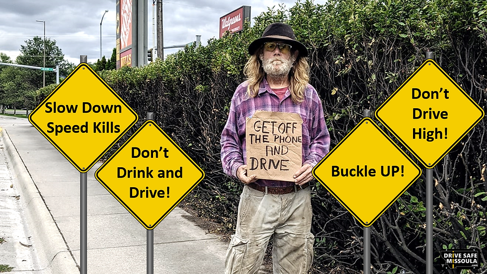 A long haired bearded guy holding a cardboard sign on a street corner. The sign says "Get Off The Phone and Drive." He's standing on the corner asking for money from cars. Photoshoped next to him are 4 traffic warning signs that say the following: Slow Down, Speed Kills. Don't Drink and Drive. Buckle Up. and Don't Drvie High.