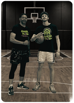 2 men wearing black shirts with green and purple text reading HOOPER HOWSE TRAINER is on a basketball court