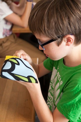 Enfant en train de coudre dans un atelier créatif Bobines et Combines