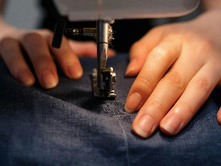 Une élève de Bobines et Combines en train de coudre à la machine