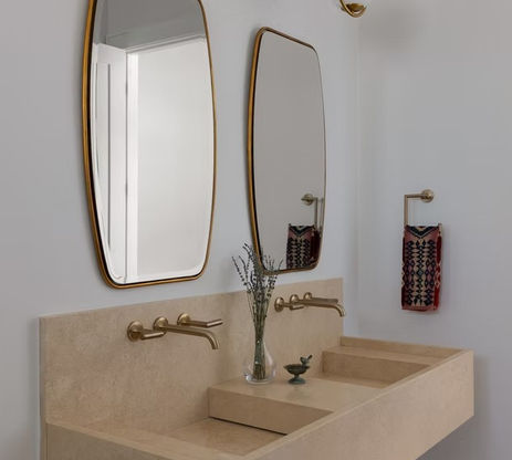 Modern double vanity with gold mirrors and wall faucets
