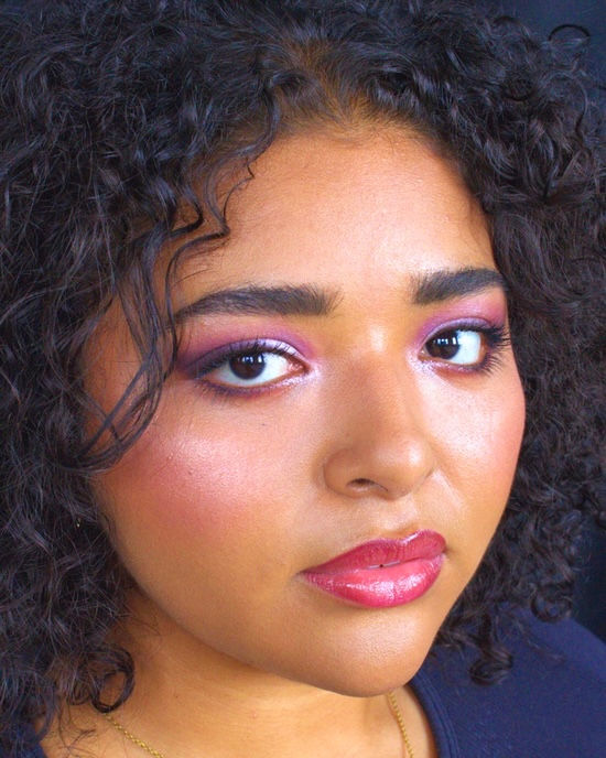 Close-up view of makeup brushes and foundation palette on a white surface