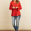 Thumbnail: Woman in red criss cross neck long sleeve top and jeans