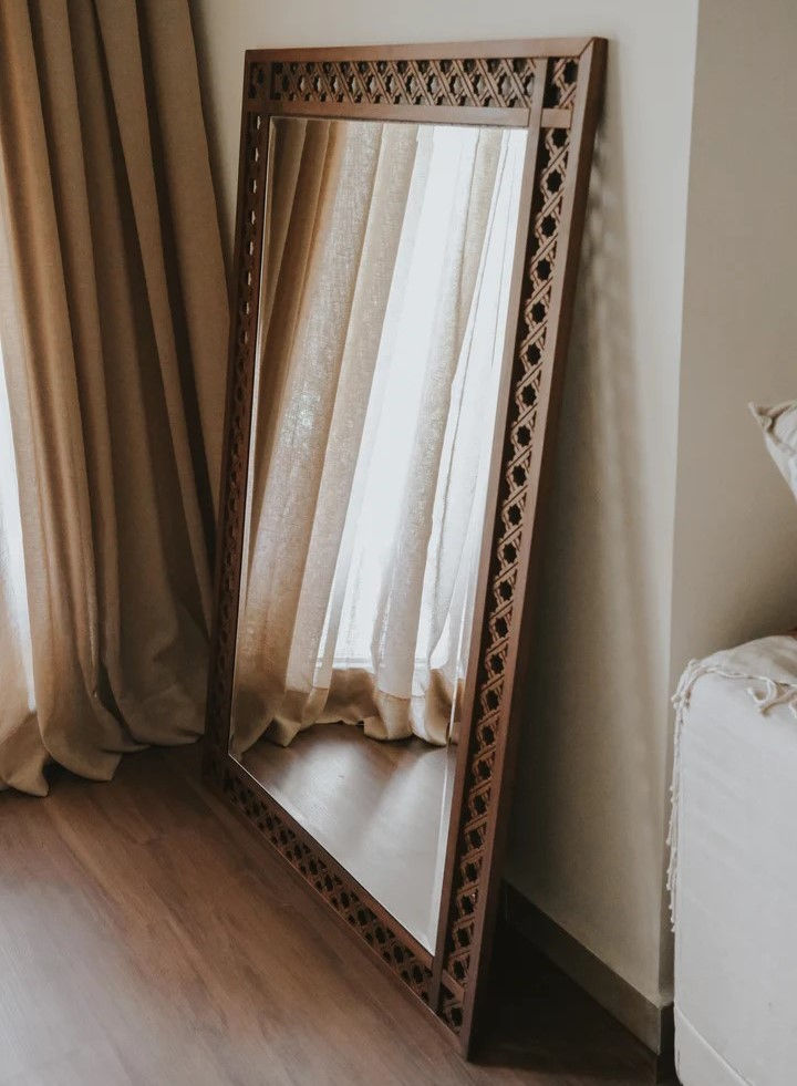 Miniature : Grand arabesque wood mirror frame leaning against the wall with a bright light atmostphere in the room