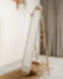 Slant shelf ladder mirror standing in the corner of the room