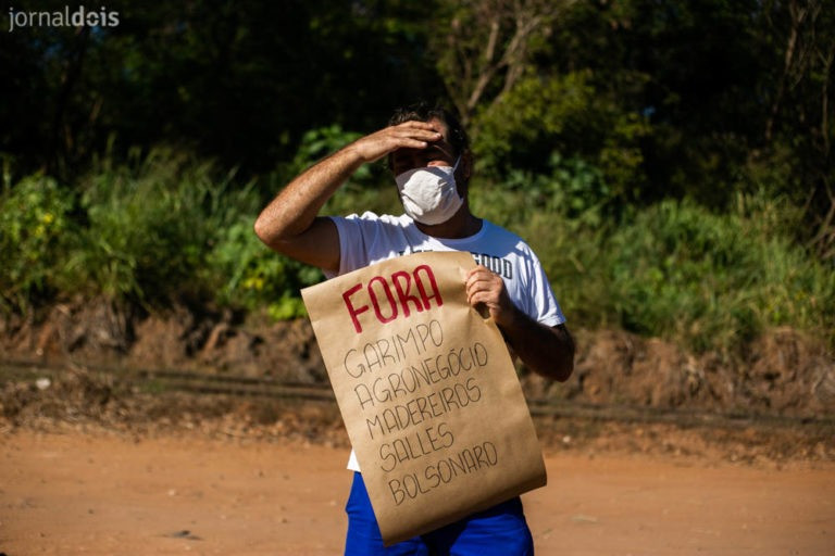 Protestante contra a vinda do ministro Ricardo Salles segura cartaz com os direzes "fora garimpo, agronegócio, madereiros, Salles e Bolsonaro".