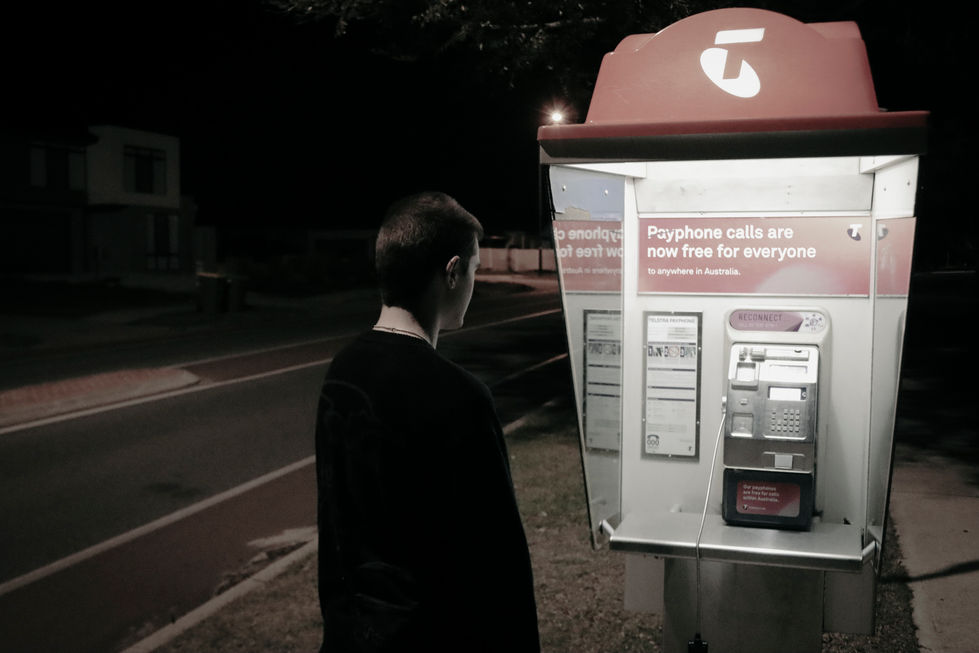 Night time dark street man at payphone roadside eery