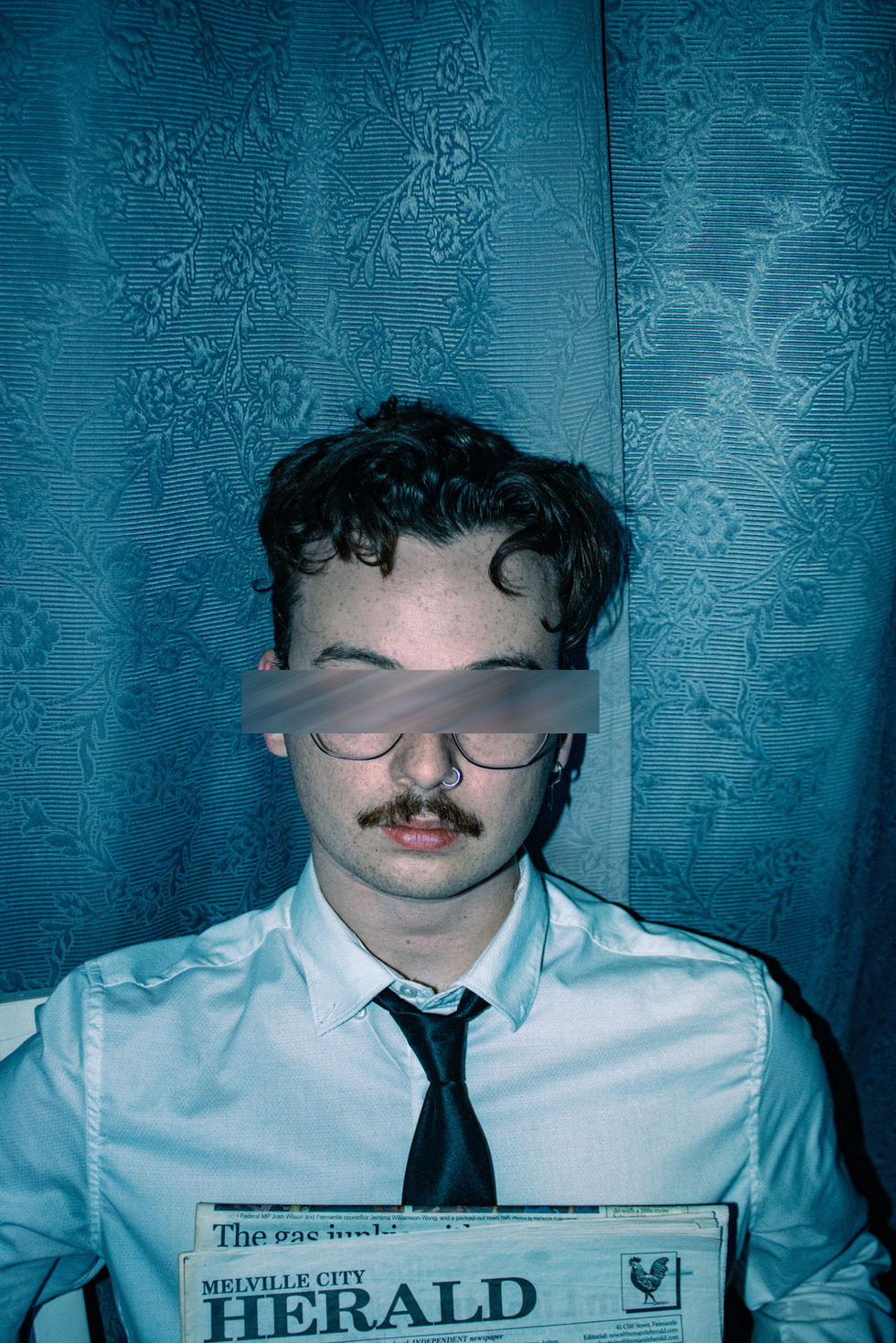 Contemporary conceptual business man close up holding newspaper to chest and eyes blurred out