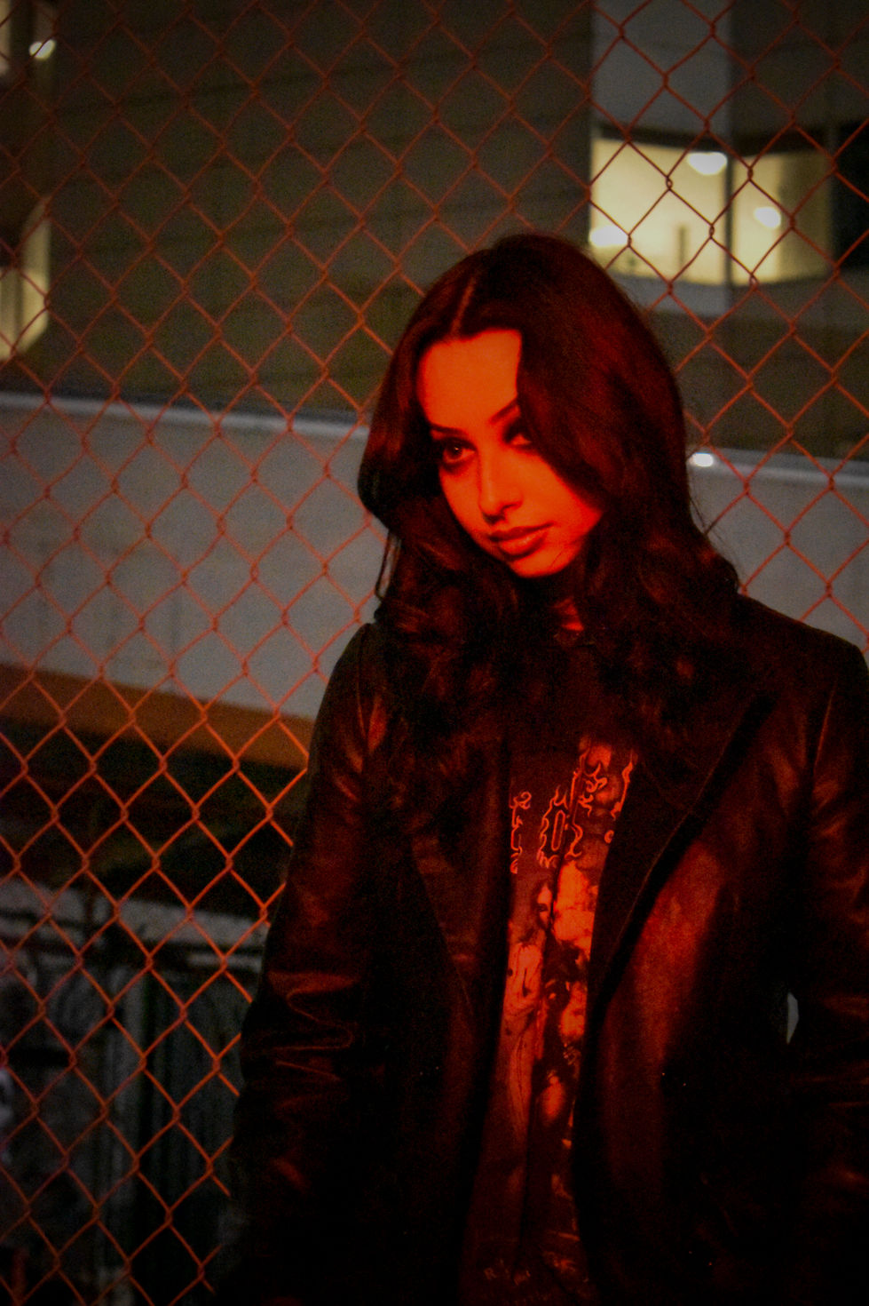 Neon lights at night shining on model close up staring down lens head tilted