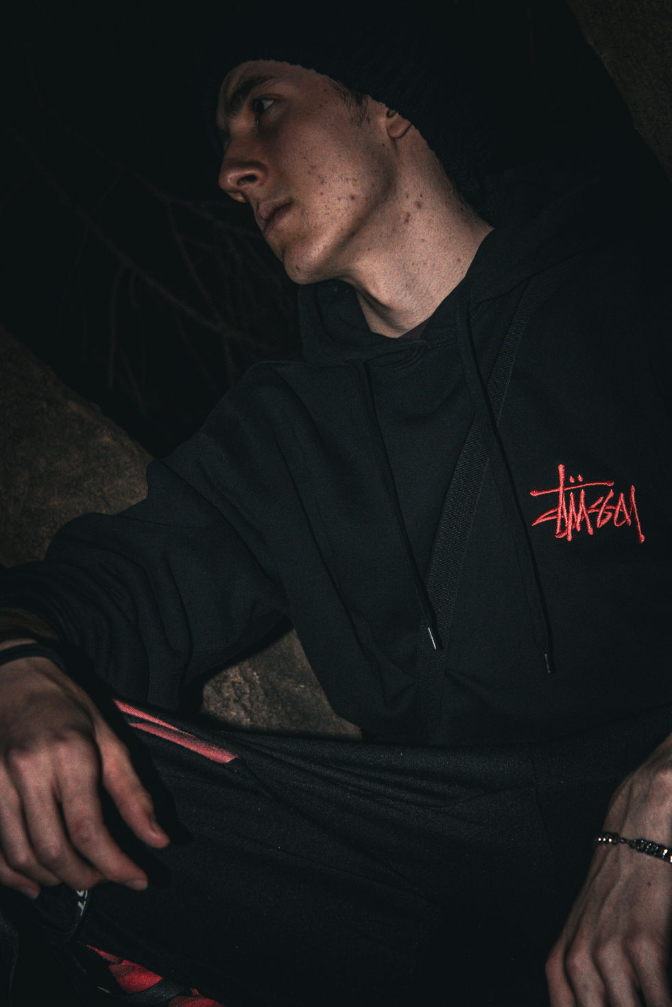 Close up of man's body and partial face staring out in skatepark at night