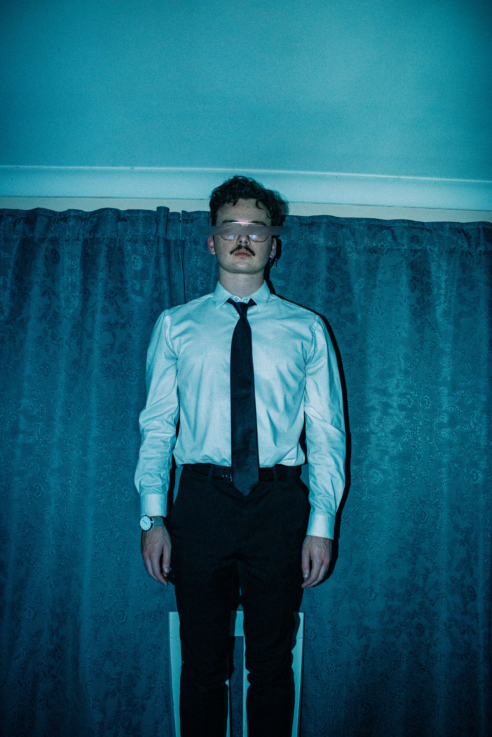 Contemporary conceptual business man at dining table alone standing on top of chair and eyes blurred out