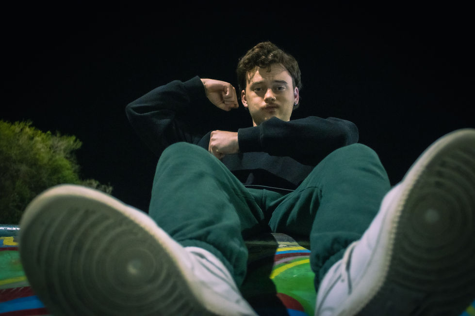 Man staring into camera with funny pose, low angle in skatepark, lightness 8/10