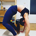 Yoga teacher performing a very deep back bend posture for advance students