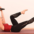 Pilates teacher doing abs routine using props to tonify abs
