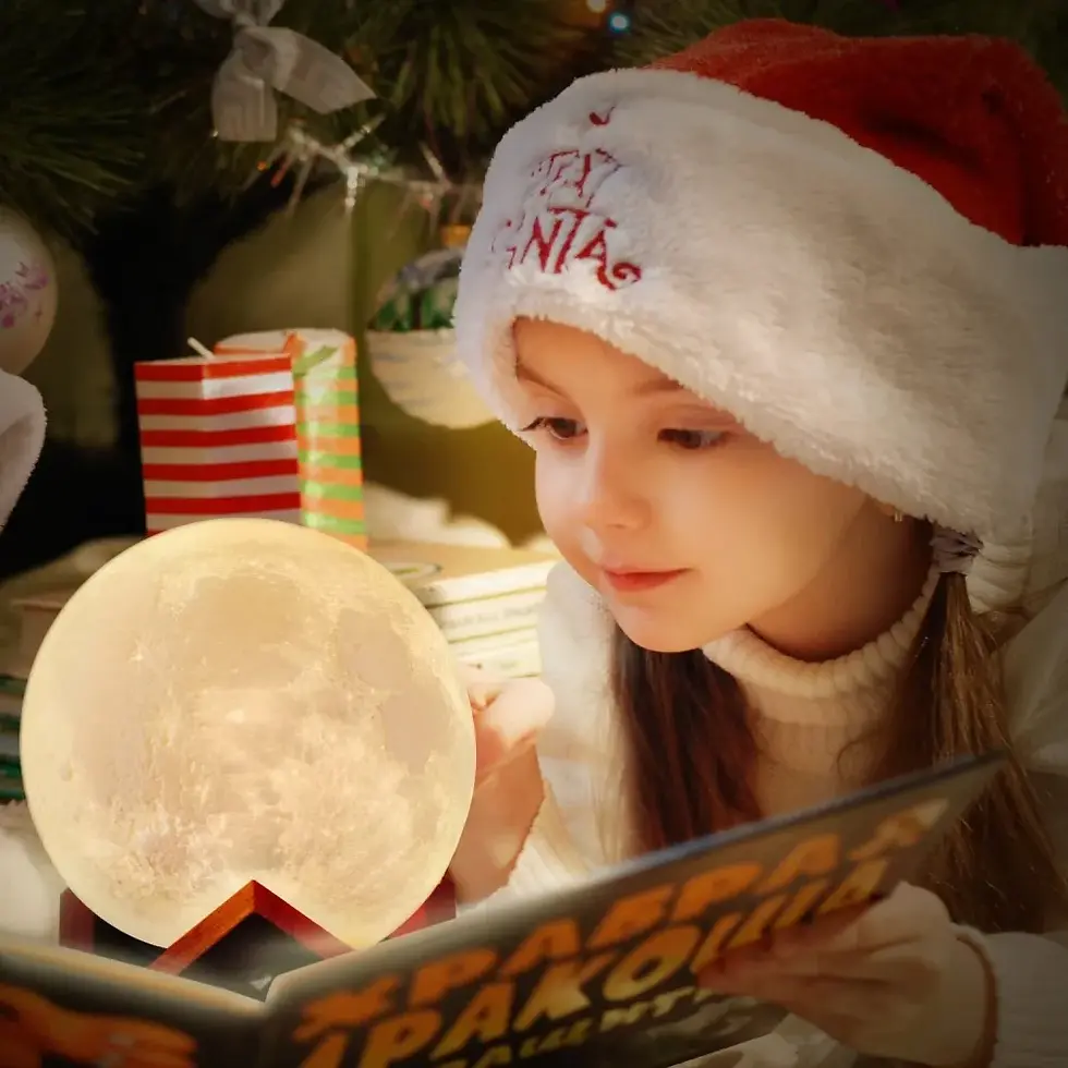 Miniatura: Criança lendo um livro iluminada pela luminária Lua LED em ambiente aconchegante.