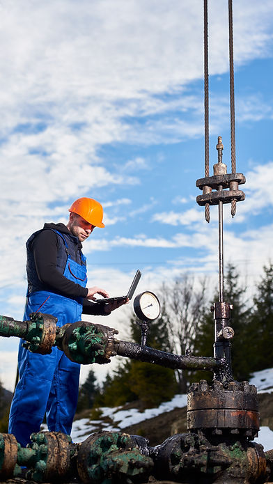 petroleum-engineer-using-laptop-oil-field.jpg
