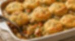 Chicken and biscuits casserole with creamy filling and golden biscuits in a white baking dish