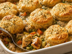 Chicken and biscuits casserole with creamy filling and golden biscuits in a white baking dish