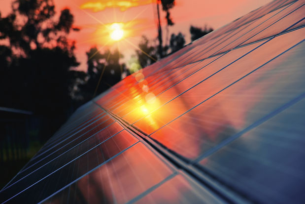 Panels of the solar energy plant with sun flare hitting the surface - clean energy concept