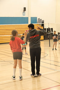Coach instructing a student during a volleyball session.