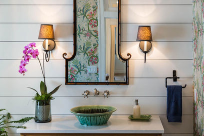 Decorative bathroom vanity with framed mirror, sconces, and floral accents