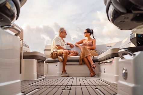 Couple seated together inside the cockpit of a luxury boat