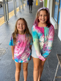 Two yound girls wearing colourful tye dye shirts