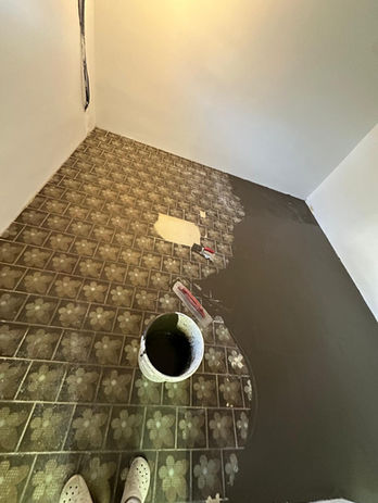 Der bestehende Fliesenboden wird gereinigt, gespachtelt und für die Weiterverarbeitung vorbereitet. Diese Methode ermöglicht eine schnelle und effiziente Sanierung ohne Herausreißen des alten Bodens.