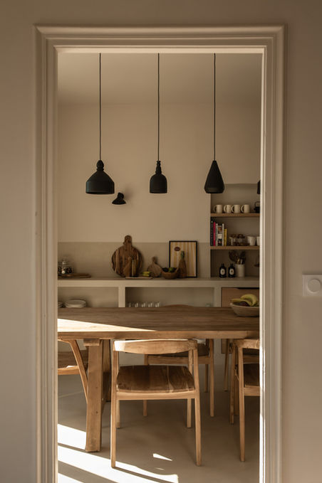 Cuisine ouverte sur salle à manger avec suspensions noires et étagères - décoration intérieure Casa Rosalie
