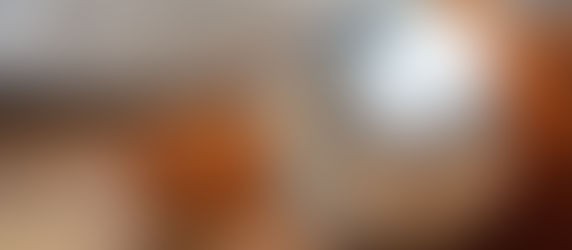 Close-up of silver and brown headphones on a wooden surface, with a blurred background. The mood is calm and focused.