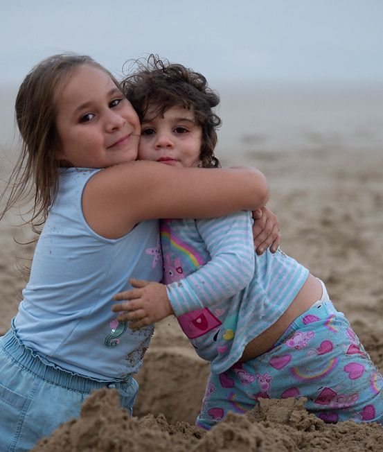 Two children hugging on the beach during a Magical Getaway Foundation getaway in Lorne