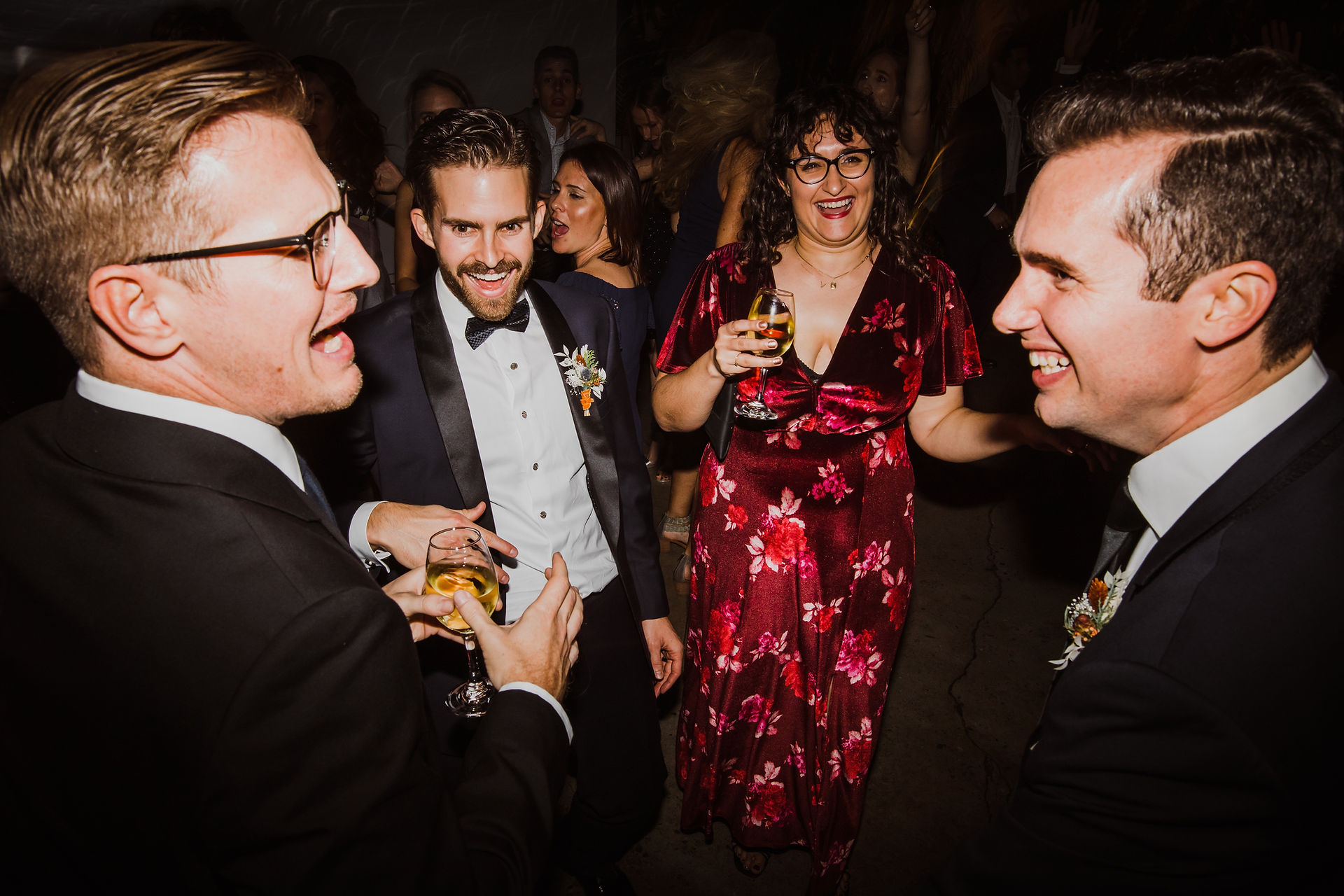 Cheerful guests standing and talking with drinks in their hands