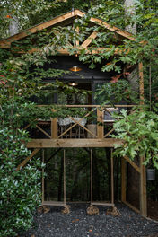 Treehouse-style fort built into foliage with rope swings, perfect for nature-based resort guest experiences.