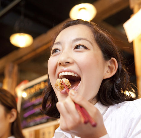 焼肉を食べて笑顔の女性