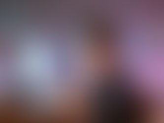 3D stylized character in glasses working intensely at a computer. Dynamic streaks of blue and pink light and floating lines of code erupt from the screen, representing the energy of compilation and the process of building universes from code.