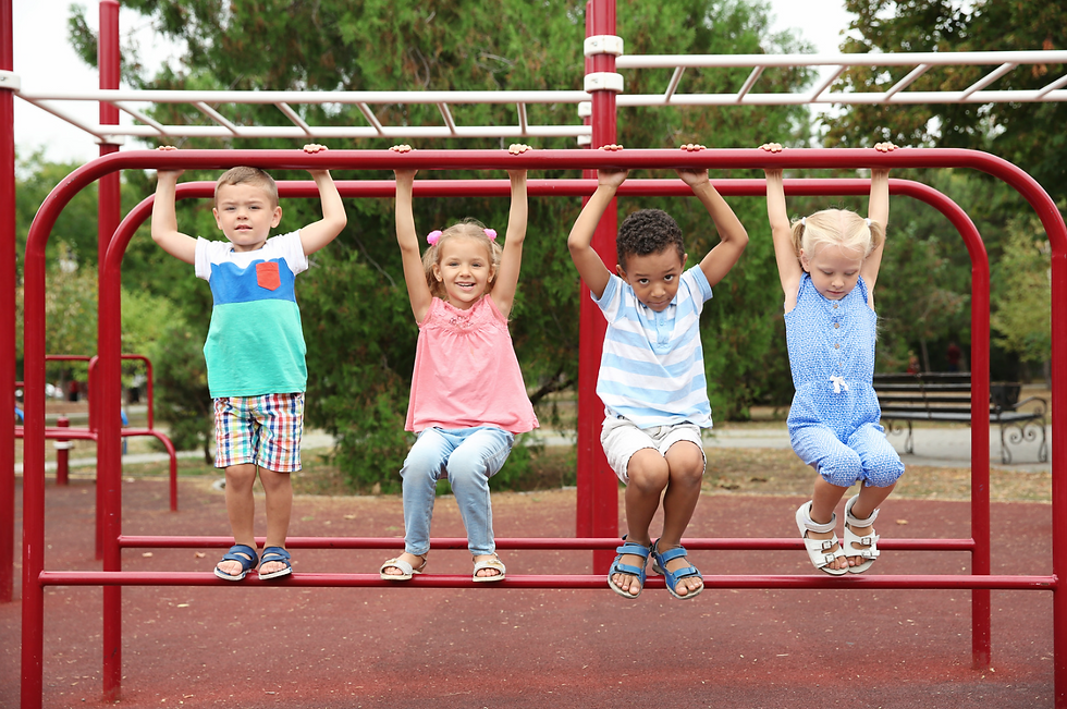 Four children playing on the monkey bars at a playground