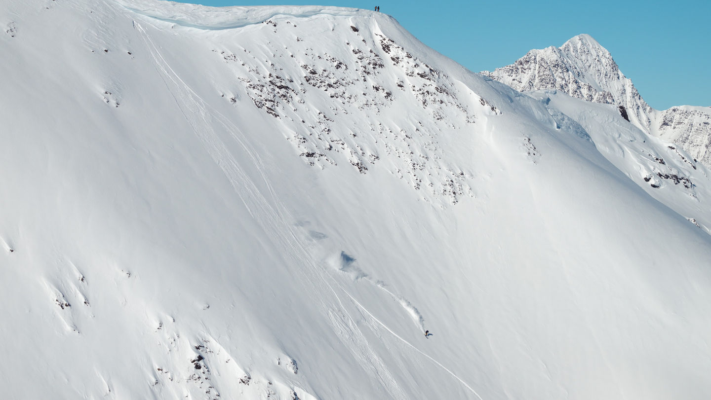 heli skiing on a mountain on a bluebird day