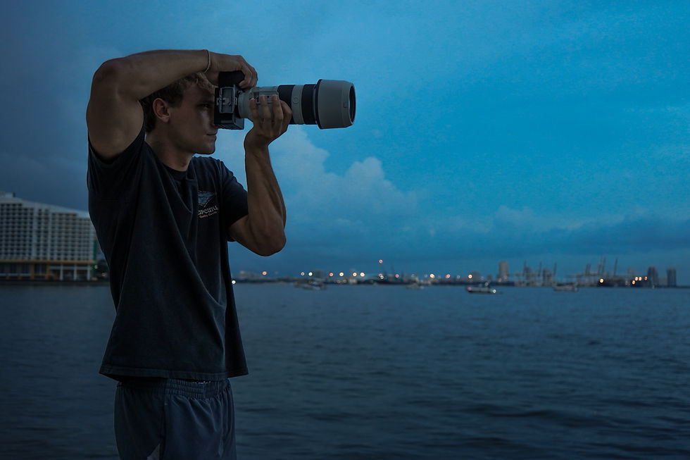 Eye-level view of a photographer capturing a sunset over the ocean