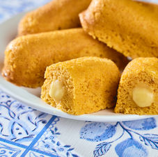 Passion fruit stuffed twinkies on a white plate set on a blue and white patterned background.