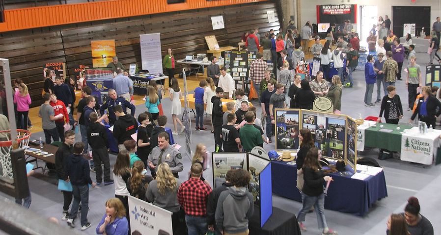 image of a career expo where students are walking around to various exhibitor booths in school gym